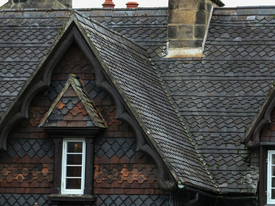 Dark slate roof with two gabled dormer windows, after the re-roof