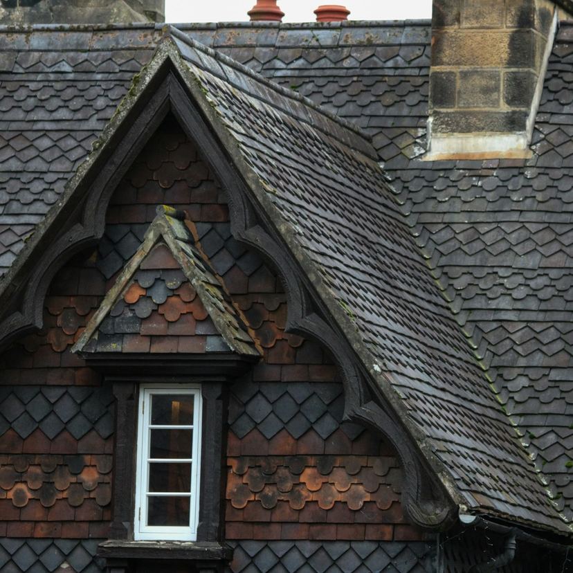Dark slate roof with two gabled dormer windows, after the re-roof