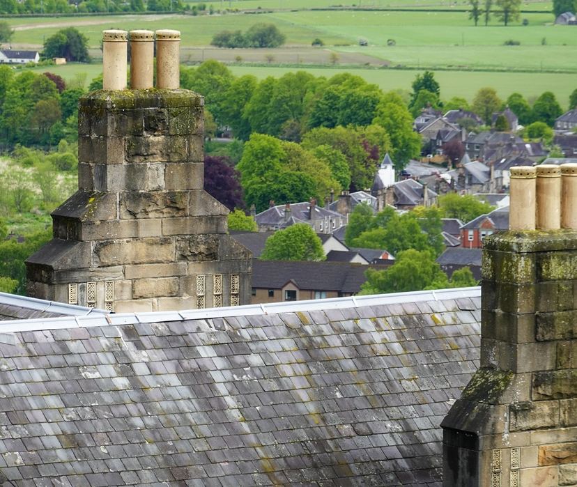 Slate roof with stone chimney stacks, looking out over the town and fields
