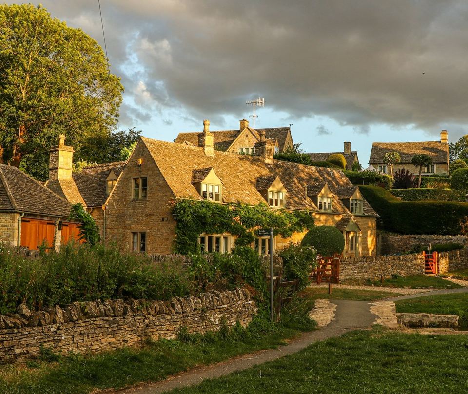 Stone cottages with slate and stone roofs in low golden evening light