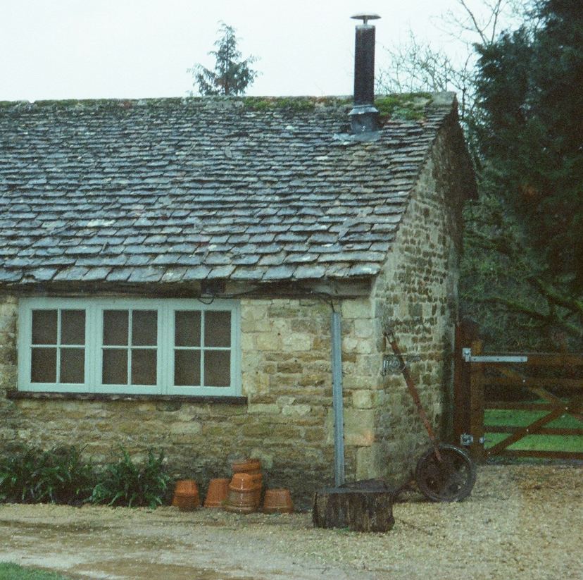 Stone cottage with a mossy slate roof and a brick chimney